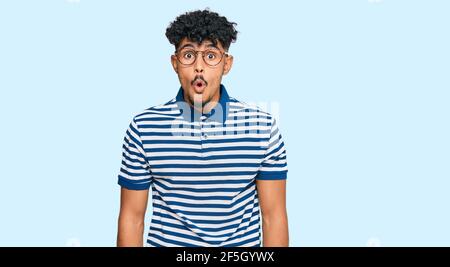 Junger arabischer Mann in legerer Kleidung und Brille ängstlich und schockiert mit überraschenden Ausdruck, Angst und aufgeregt Gesicht. Stockfoto