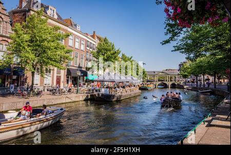 LEIDEN, NIEDERLANDE - 27. JUNI 2018: Boote mit Touristen auf Kanal an einem sonnigen Sommertag, Stadtzentrum von Leiden, Niederlande Stockfoto