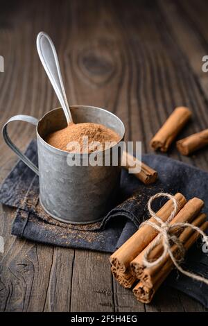 Gesunde Lebensmittel Würze mit medizinischen Eigenschaften, echte Ceylon Zimt Sticks und Pulver in einem Glas auf Holz Hintergrund Stockfoto