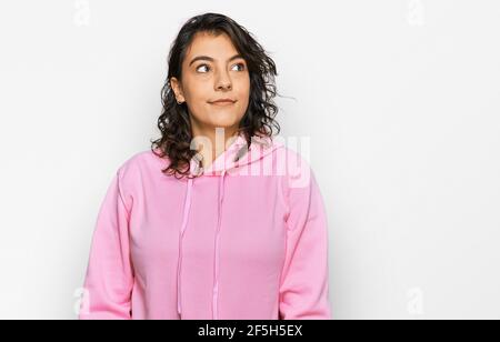 Junge hispanische Frau trägt lässige Sweatshirt lächelnd Blick zur Seite und starrte weg denken. Stockfoto