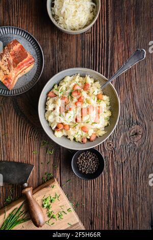 Kapustove halusky bekannt als Strapacky, klassisches Gericht in der Slowakei, gekochte Kartoffelknödel mit Sauerkraut und Zwiebel, gekrönt mit gebratenem Speck und frischem c Stockfoto