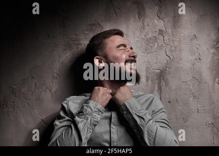 Ein hübscher junger Mann mit Bart. Die Emotionen eines Mannes. Depression oder Hoffnungslosigkeit. Dramatisches emotionales Porträt eines Mannes. Hochwertige Fotos Stockfoto