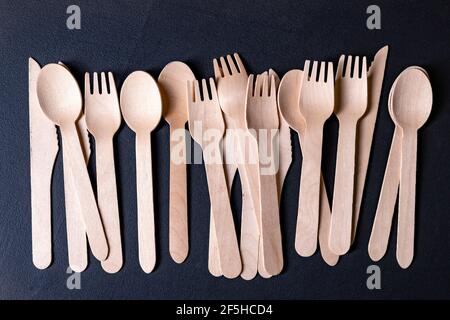 Einwegbesteck aus Holz. Zubehör zum Essen im Freien. Dunkler Hintergrund. Stockfoto