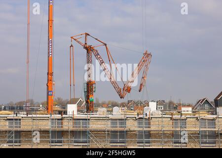 Mobile Turmdrehkrane heben auf der niederländischen Baustelle Wohngebäude Stockfoto