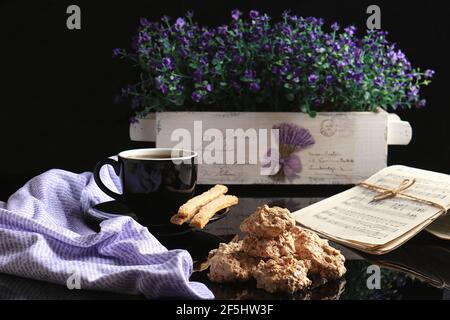 Eine morgendliche Tasse heißen Kaffee mit Blumen und Musik. Stockfoto