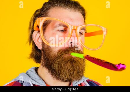 Schöner Mann mit Party-Horn-Gebläse. Menschen, Geburtstag und Feier Konzept. Stockfoto