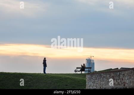 BELGRAD, SERBIEN - 1. JANUAR 2021: Paare, Liebhaber, Touristen, die Fotos machen und im Festungspark Kalemegdan posieren mit einem Panorama der Skyscra Stockfoto
