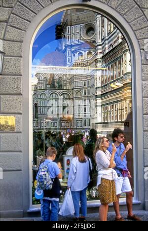 Familie im Urlaub genießen Gelato, während sie den Dom bewundern, der sich in Schaufenster in den Straßen von Florenz, Italien, widerspiegelt. Stockfoto