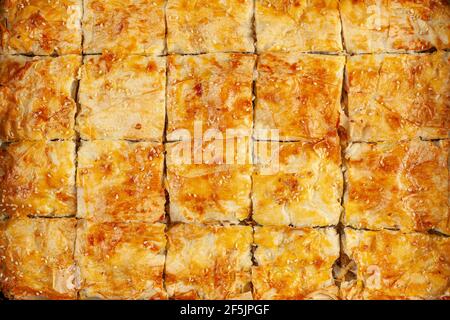 Draufsicht auf ein Tablett mit traditionellen türkischen Kiymali borek. In quadratische Stücke geschnitten. Nützlich für Hintergrund und Textur. Köstliche hausgemachte authentisch Stockfoto