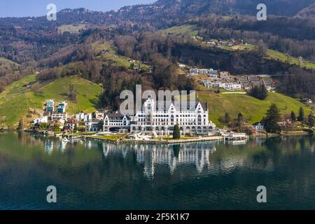 Vitznau, Schweiz - März 28 2020: Dramatische Luftaufnahme des luxuriösen Park Hotel Vitznau, das sich im Wasser des Vierwaldstättersees in Zentral spiegelt Stockfoto