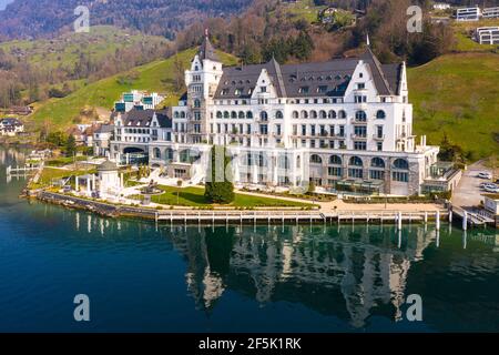 Vitznau, Schweiz - März 28 2020: Dramatische Luftaufnahme des luxuriösen Park Hotel Vitznau, das sich im Wasser des Vierwaldstättersees in Zentral spiegelt Stockfoto