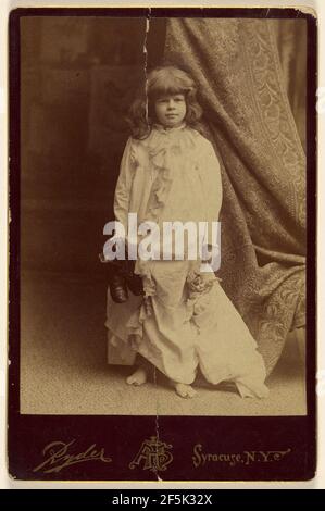 Ethel Butter in weißem Morgenmantel, hält ein Paar Schuhe und eine Puppe, stehend. Philip S. Ryder (amerikanisch, aktiv 1870s - 1920s) Stockfoto