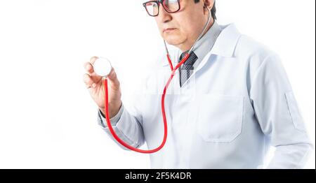 Latino Arzt in weißem Mantel und Brille hält ein Stethoskop in Position, um das Herz und die Lunge eines Patienten zu überprüfen. Krankenhaus, Medizin und medizinische di Stockfoto