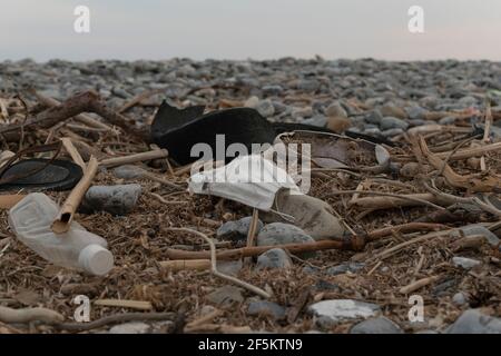 Verschmutzung am Strand, Plastik inklusive Flaschen, OP-Masken und anderen Müll Stockfoto