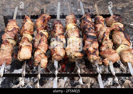 Grillen von Fleisch auf Spiessen. Kochen Fleisch Grill auf Holzkohlegrill bei Picknick. Döner Grillen. Stockfoto