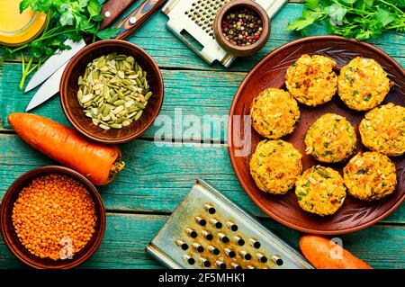 Teller mit vegetarischen Linsen und Karottenschnitzel.Diät-Essen.Gemüseschnitzel auf Holz rustikalen Tisch. Stockfoto