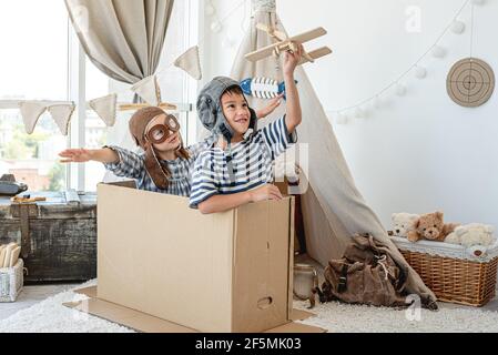 Kleiner Junge und kleines Mädchen spielen Piloten Stockfoto