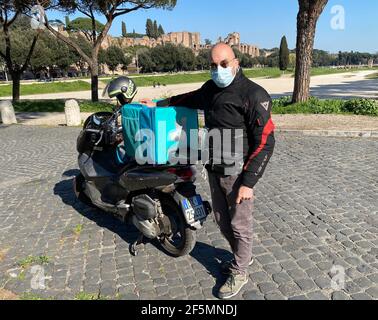 Rom, Italien. März 2021, 25th. Food Delivery Rider Antonello Badessi posiert für ein Foto im Circus Maximus in Rom, Italien, am 25. März 2021. Die Coronavirus-Pandemie hat einen Boom für Unternehmen ausgelöst, die Dienstleistungen für die Lebensmittelversorgung anbieten. Antonello Badessi, einer der am längsten arbeitenden Fahrer der Lebensmittelzustellung in Rom, sagte jedoch, dass die meisten Vorteile nicht auf diejenigen, die Lieferungen gemacht haben, heruntergekommen sind. UM MIT "Feature: Food Delivery Rider in Rom sagt, seine Branche ändert sich schneller durch Pandemie" Quelle: Str/Xinhua/Alamy Live News Stockfoto