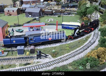 East Asiatic Company eine Merchant Navy-Lokomotive, die einen Bergungskran auf einer Modelleisenbahn zieht. Stockfoto