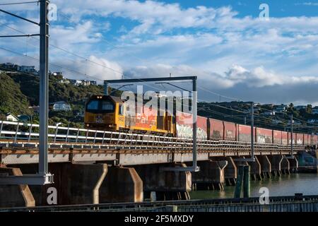 DL-Lokomotive mit Güterzug über Paremata Bridge, Paremata, Wellington, Nordinsel, Neuseeland Stockfoto