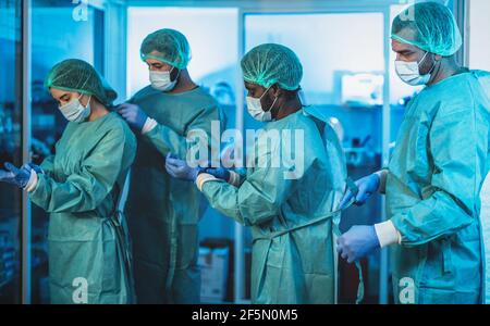 Ärzte, die sich auf eine Operation im Krankenhaus während des Corona-Virus-Ausbruchs vorbereiten - Medizinische Mitarbeiter, die sich für den Kampf gegen Coronavirus vorbereiten Stockfoto
