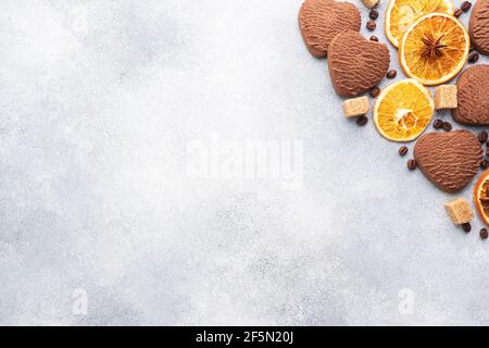 Schokolade Herzkekse, Orangen Zimt und würzige Gewürze auf einem grauen Tisch, Draufsicht, Kopierraum Stockfoto