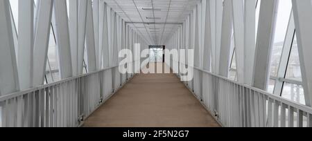 Viadukt, Fußgängerbrücke über die Straße. Selektiver Fokus. Überdachter langer Tunnel. Stockfoto