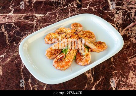 Gegrillter Tintenfisch nach traditionellen japanischen Rezepten. Speicherplatz kopieren. Vor dem Hintergrund eines Marmortisches, Nahaufnahme. Stockfoto