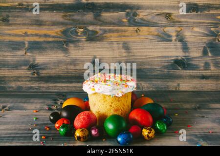 Osterkuchen auf einem hölzernen Hintergrund. Mehrfarbige Ostereier. Stockfoto