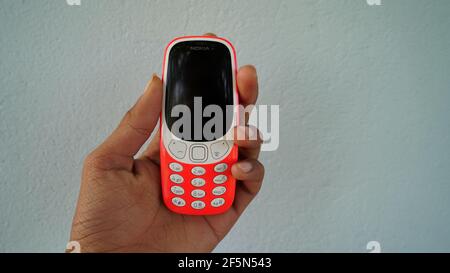 Rajasthan, Indien - 20. März 2021; EIN Mann hält Nokia Tastatur mobile Modell 3310 mit schwarzem Bildschirm isoliert auf weißem Hintergrund. Smartphone-Taste I drücken Stockfoto