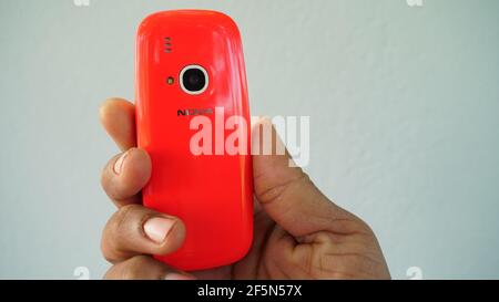 Rajasthan, Indien - 20. März 2021; EIN Mann hält Nokia Tastatur mobile Modell 3310 mit schwarzem Bildschirm isoliert auf weißem Hintergrund. Smartphone-Taste I drücken Stockfoto