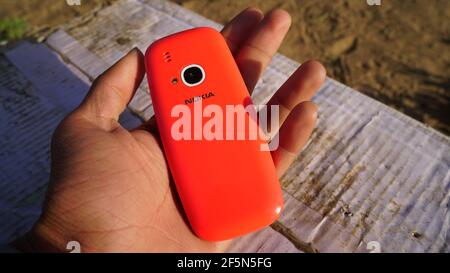 Rajasthan, Indien - 20. März 2021; EIN Mann hält Nokia Tastatur mobile Modell 3310 mit schwarzem Bildschirm isoliert auf weißem Hintergrund. Smartphone-Taste I drücken Stockfoto