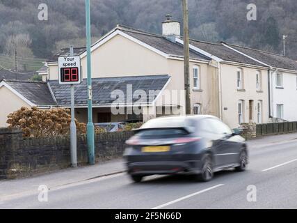 Auto, das durch Dorf auf Ihrem Geschwindigkeit digitalen Zeichen in 30mph Limit gefangen, Llanfoist, Wales, Großbritannien Stockfoto