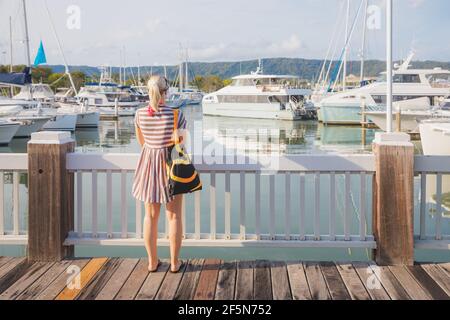 Port Douglas, Australien - Januar 6 2020: Eine junge blonde Touristenattraktion besucht an einem Sommertag die Crystalbrook Superyacht Marina in Port Douglas, Queensl Stockfoto