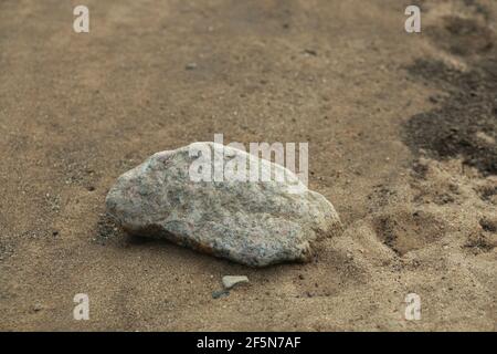 Nahaufnahme eines Steines an einem Sandstrand Stockfoto