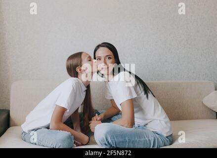 Ein großes Porträt einer liebevollen Tochter, die ihre Mutter auf die Wange küsst. Glückliche Mutter und Tochter des gegenseitigen Verständnisses in der Familie Stockfoto