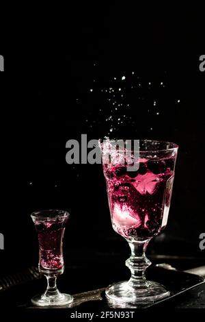 Beerengetränk. Dunkle Fotografie. Vorderseite des Glases im Fokus. Stockfoto