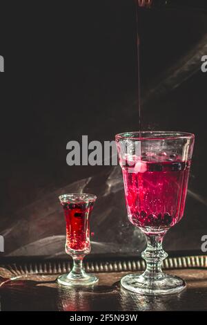 Beerengetränk. Dunkle Fotografie. Vorderseite des Glases im Fokus. Stockfoto