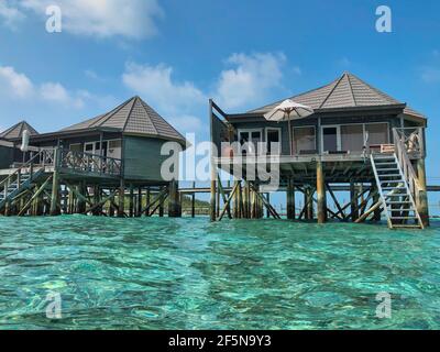 Villa mit türkisfarbenem Ozean auf den Malediven. Wunderschöner Blick auf die Bungalows über dem Wasser mit Laccadive Meer im maledivischen Resort Komandoo. Stockfoto