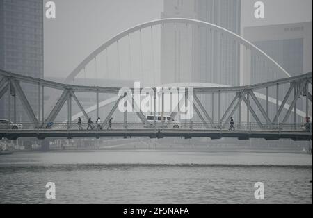 Tianjin. März 2021, 27th. Das Foto vom 27. März 2021 zeigt Menschen und Fahrzeuge, die im Nebel in Tianjin, Nordchina, eine Brücke überqueren. Quelle: Sun Fanyue/Xinhua/Alamy Live News Stockfoto
