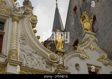 Detail des Daches des alten Zivilregisters mit vergoldeten Statuen, auf dem Burgplatz, Brügge, Belgien. Stockfoto