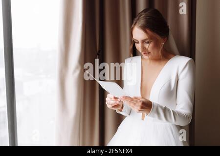 Hochzeitstag. Gebühren im Hotel. Die Braut am Fenster und liest den Brief an den Bräutigam. Eheversprechen. Vorbereitungen. Der Morgen der Braut. Braut i Stockfoto