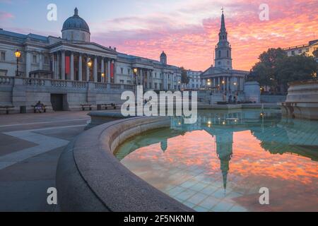 Am Trafalgar Square und in der National Gallery im Zentrum von London, Großbritannien, erwartet Sie ein farbenfroher, dramatischer Sonnenaufgang oder Sonnenuntergang. Stockfoto