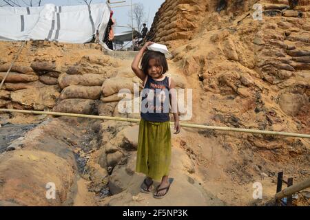 Ein Kind sitzt auf freiem Himmel, nachdem ein riesiges Feuer am Montag durch ein Rohingya-Flüchtlingslager im Süden von Bangladesch gefegt und Tausende von Häusern zerstört hat Stockfoto