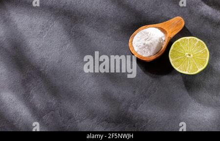 Backpulver im Holzlöffel mit Zitrone. Stockfoto