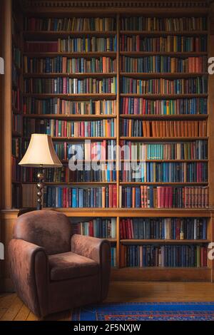Edinburgh, Schottland - Juni 5 2019: Eine gemütliche altmodische Leseecke mit stattlichen Haus Bibliothek Sammlung von Vintage-Bücher. Stockfoto