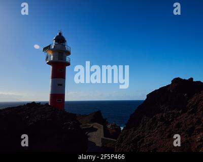 Rot ein weißes Licht Haus auf den vulkanischen Klippen der insel teneriffa, spanien, gegen den klaren blauen Himmel über dem atlantik Stockfoto