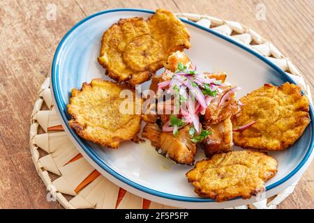 Ein Teller gebratener Kochbanane serviert mit zerfetztem Rindfleisch beträufelt Mit Zwiebel und Limettendressing Stockfoto