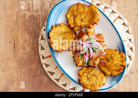 Ein Gericht gebratenen Kochbananen serviert mit geschreddertem Rindfleisch beträufelt Mit Zwiebel und Limettendressing Stockfoto