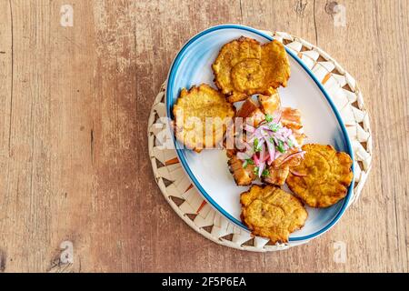 Ein Teller gebratenen Kochbananen serviert mit geschreddertem Rindfleisch beträufelt Mit Zwiebel und Limettendressing von oben Stockfoto